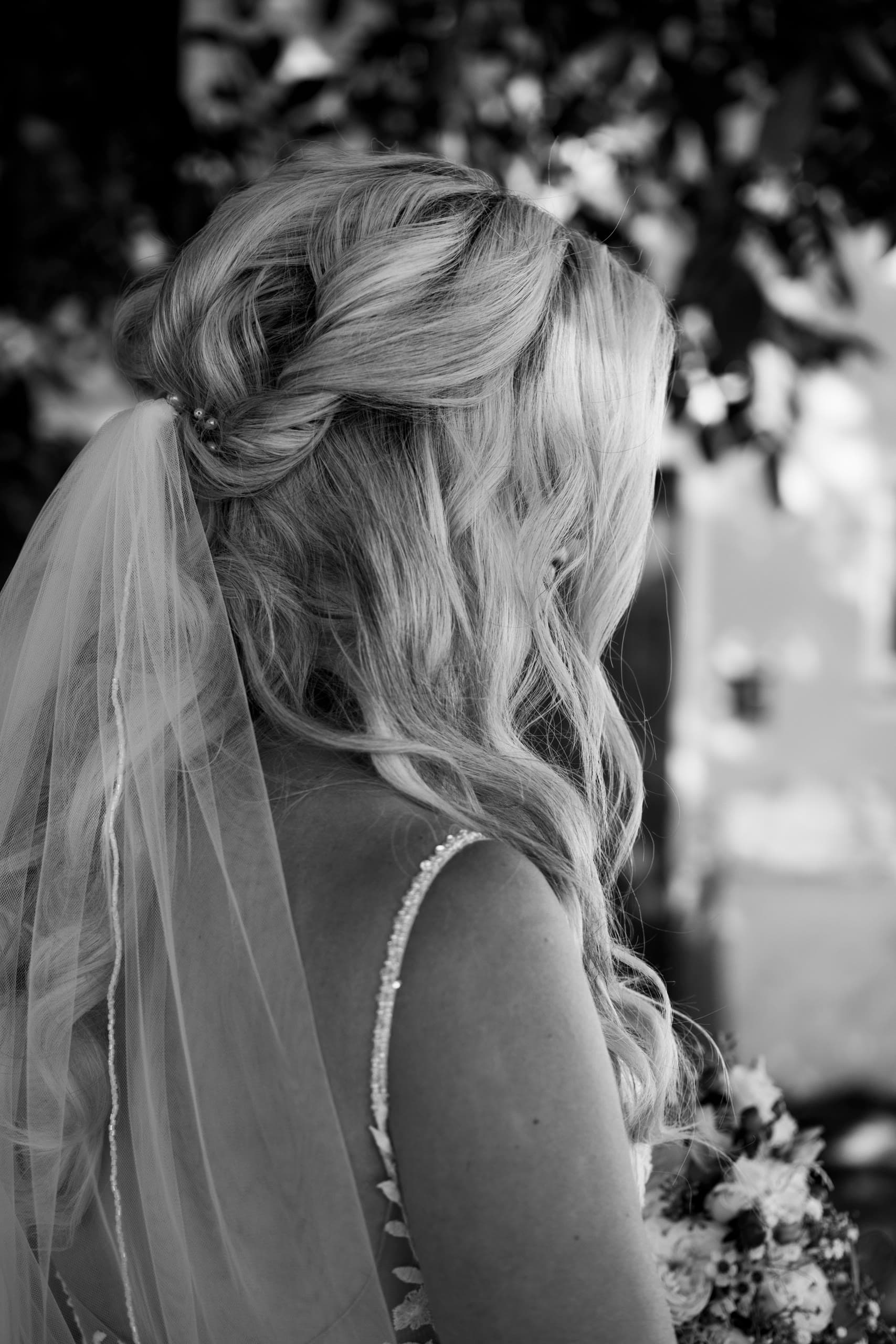 Bride's hair updo and veil seen from behind in black and white
